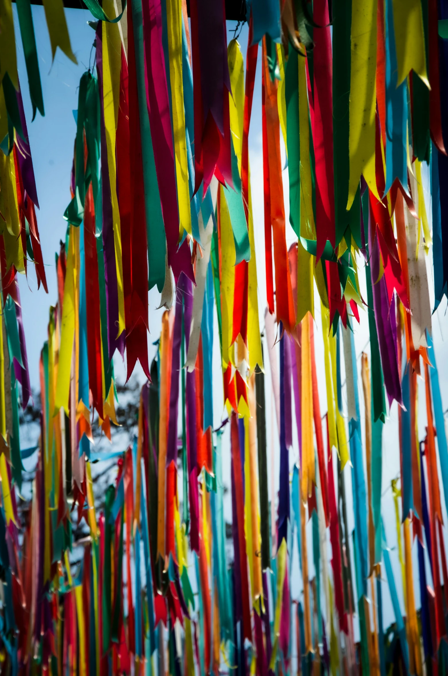 a large array of colorful streamers are hanging in the air