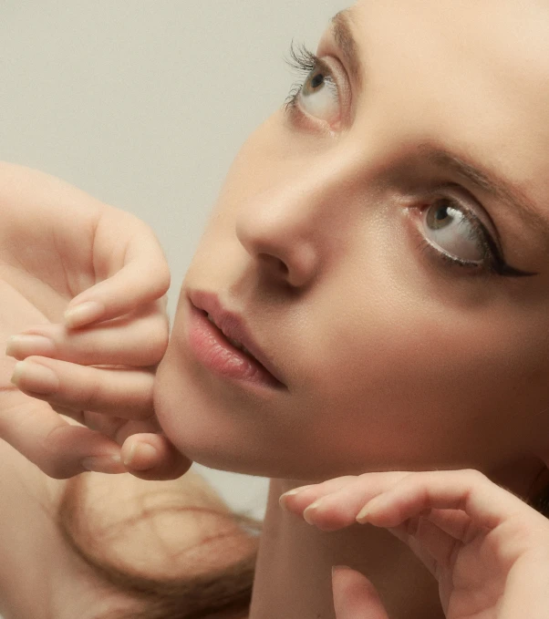 a woman is putting on some piercings and getting her nose brushed