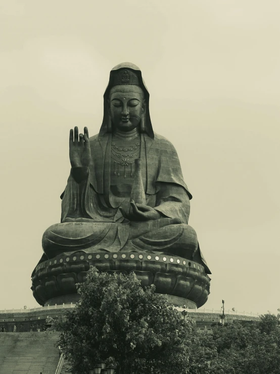 a large chinese statue sitting on top of a lush green field