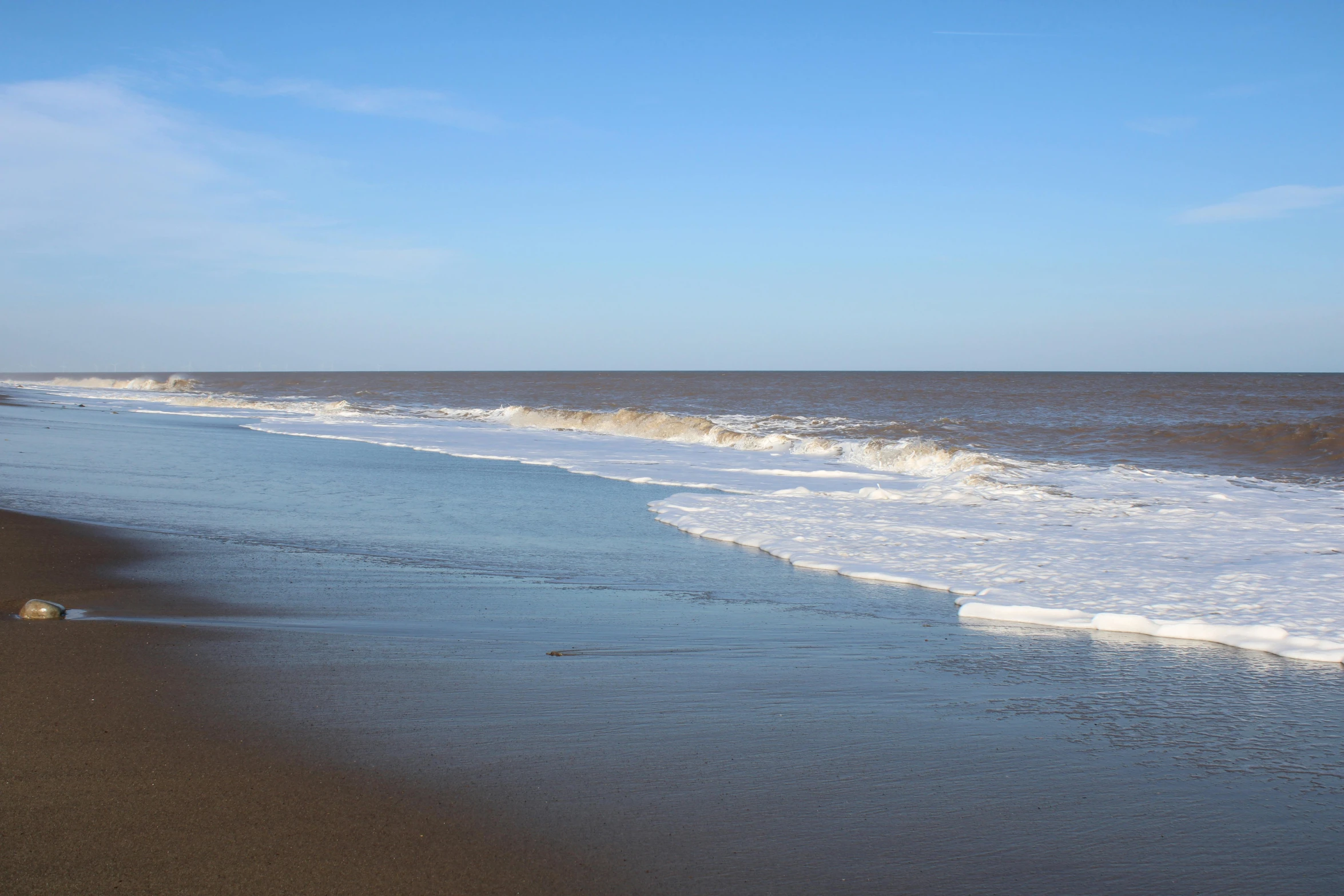 some waves coming in to a beach area