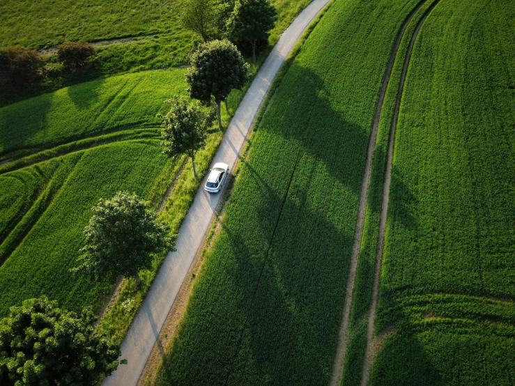 an aerial view of a truck and train on the road