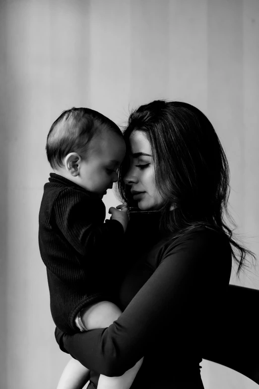 a woman holds a baby boy in her arms