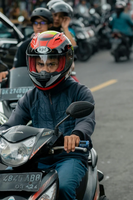 man in helmet on motorcycle with other people riding on side by side