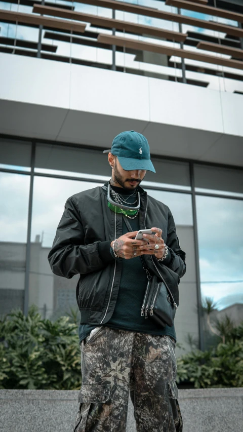 a man using his cell phone standing in front of a building