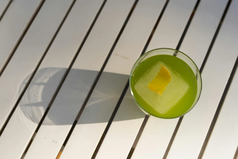 a green drink is on a white table