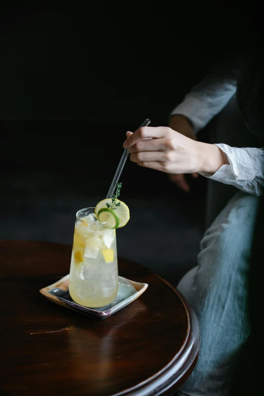 someone placing their lemon wedges on the top of the drinks glass