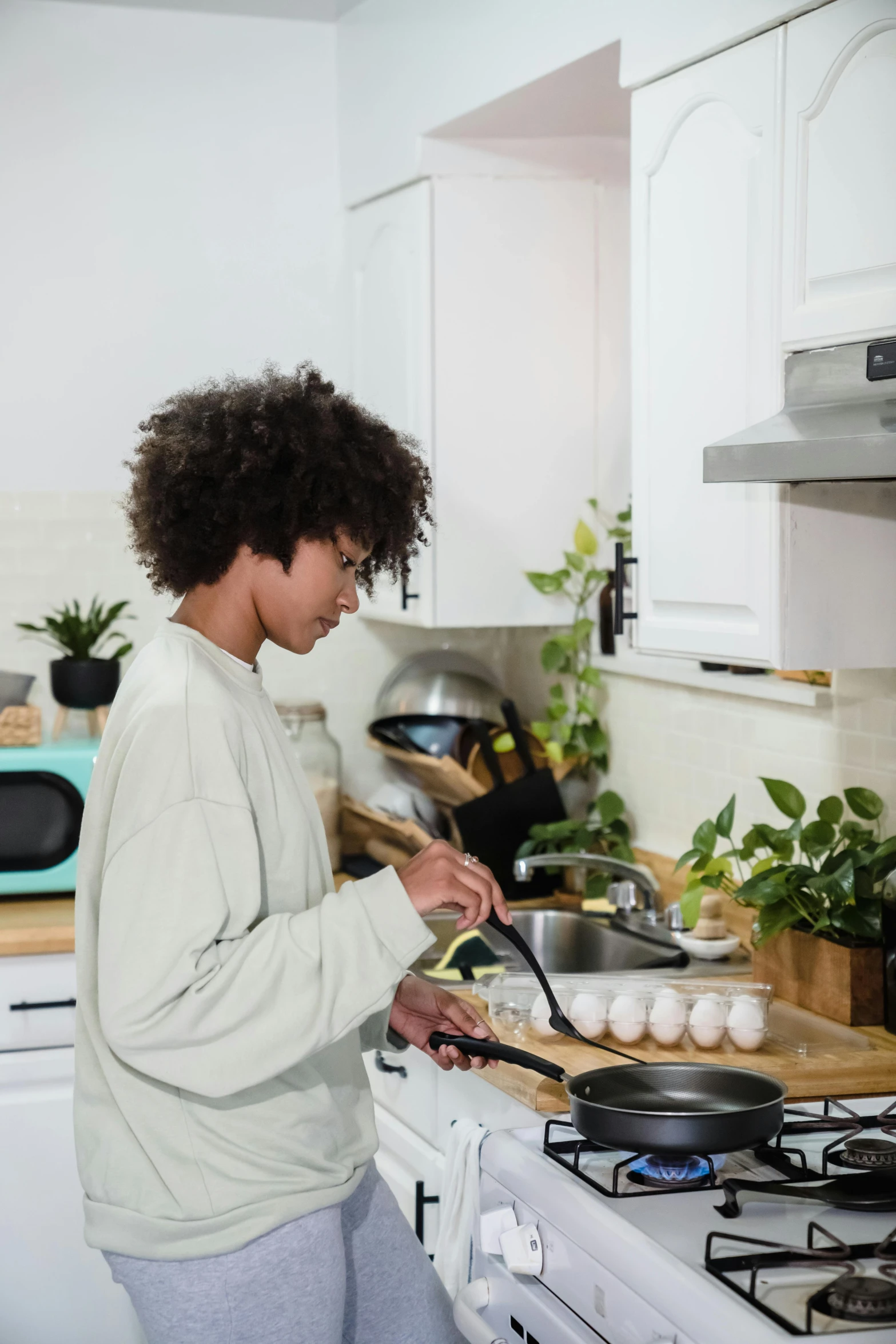 a woman standing in a kitchen cooking some food