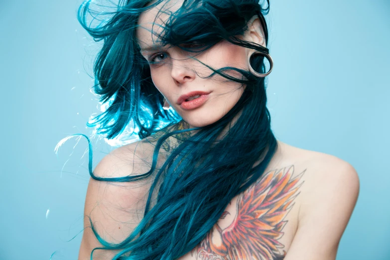 a young lady with long black hair with blue streaks and an artistic tattoo on her back