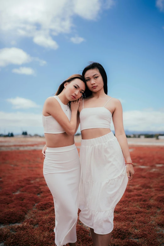 two women in white clothing posing for the camera