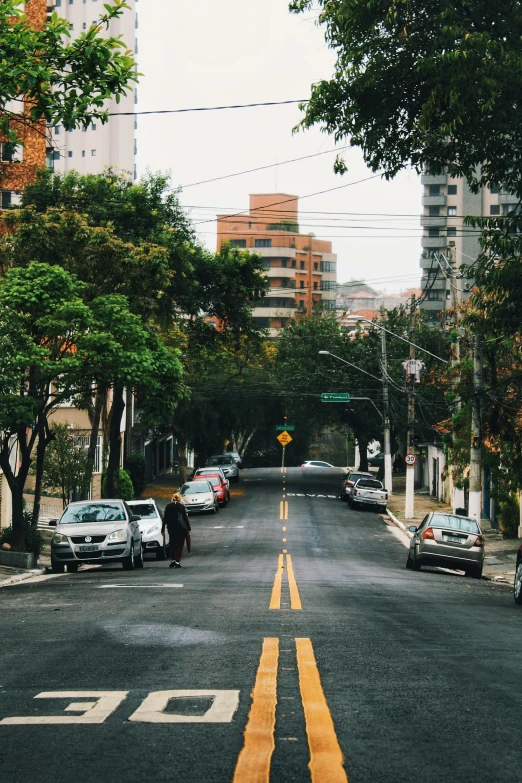 cars parked on the curb of an otherwise empty street