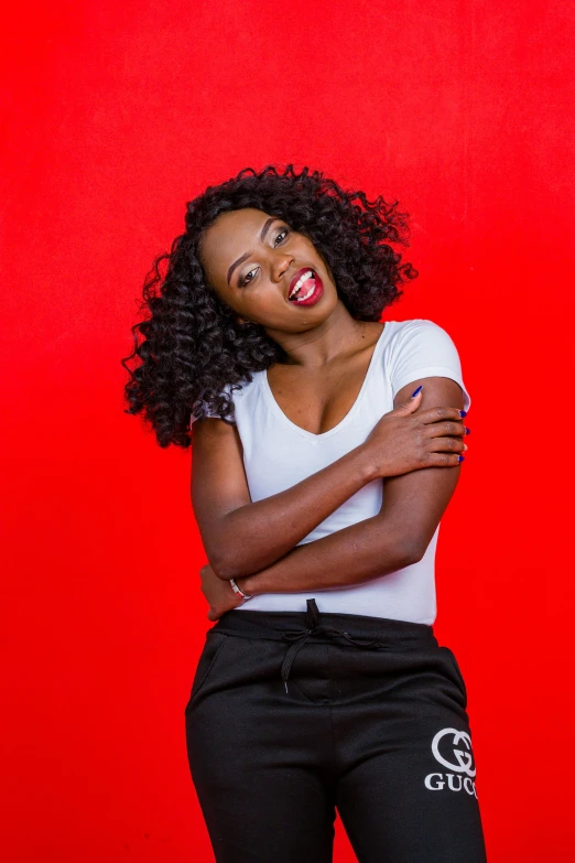 the woman smiles while posing with her arms crossed