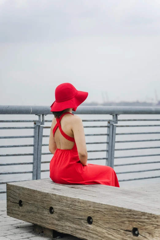a woman sitting on the dock in red