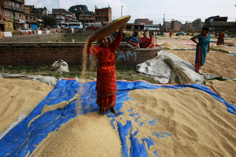 people gather in a village where sand is being milled