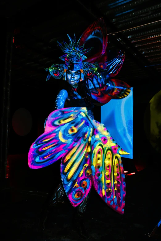 a glowing statue with large erfly wings in the dark