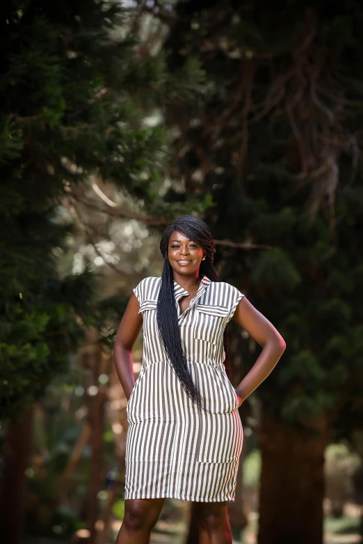 a woman in striped shirt dress posing for a pograph