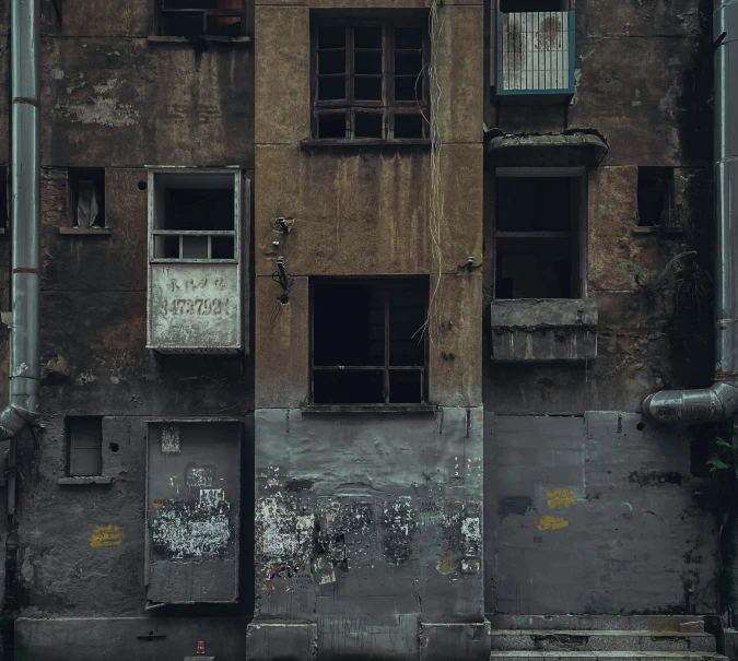 a very old building with broken windows that has graffiti on it