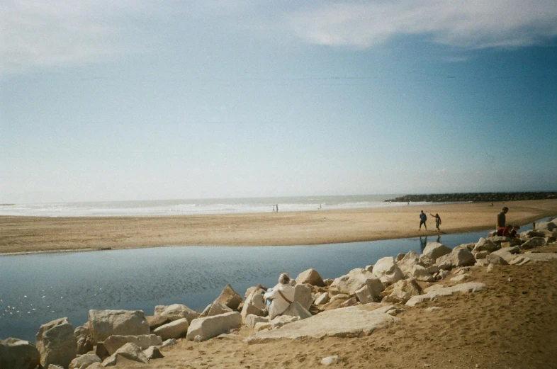 two people standing by the beach near the water