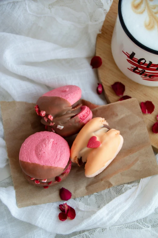 three baked goods arranged on paper and a cup of coffee