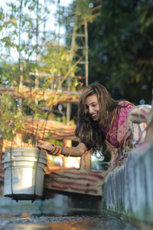 woman leaning on fence with hand full of plants