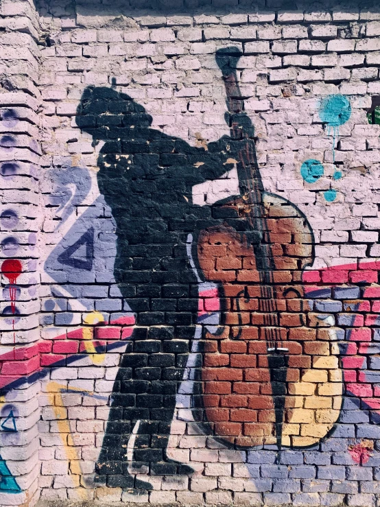 a man painting on the side of a brick wall