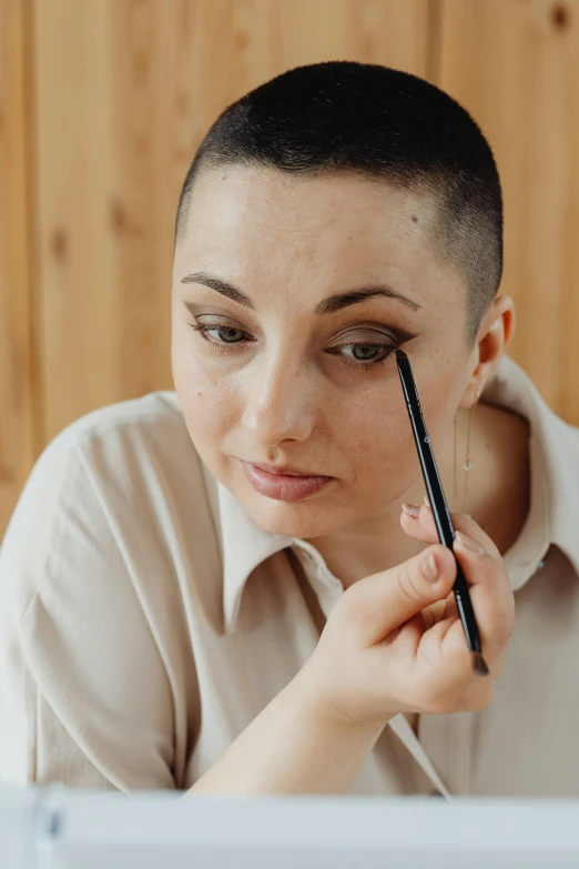 a woman with a pencil in her hand is looking at a laptop screen