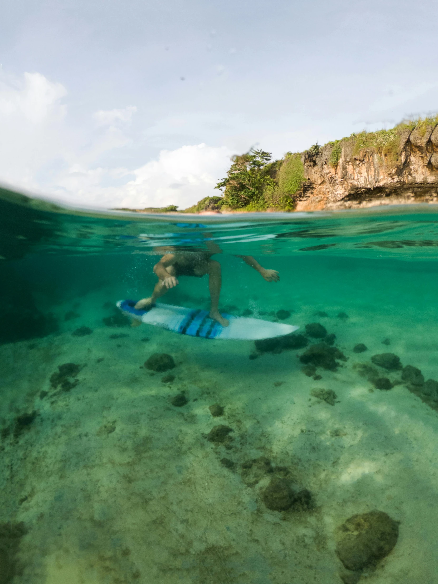 a man riding on top of a blue surfboard in the ocean