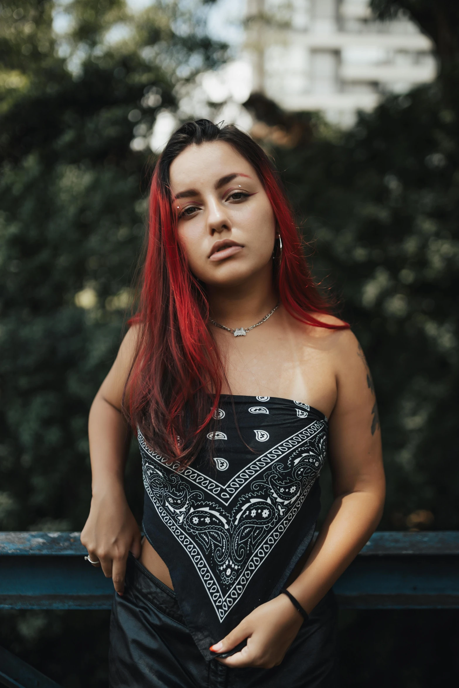 a young woman poses for a portrait near some trees