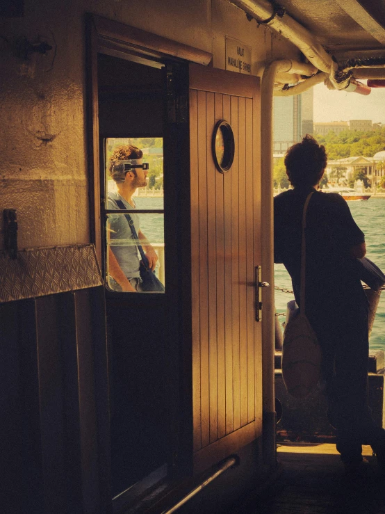 two people looking out from the back of a ship