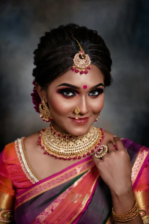 a woman in a purple and orange colored sari poses for a picture