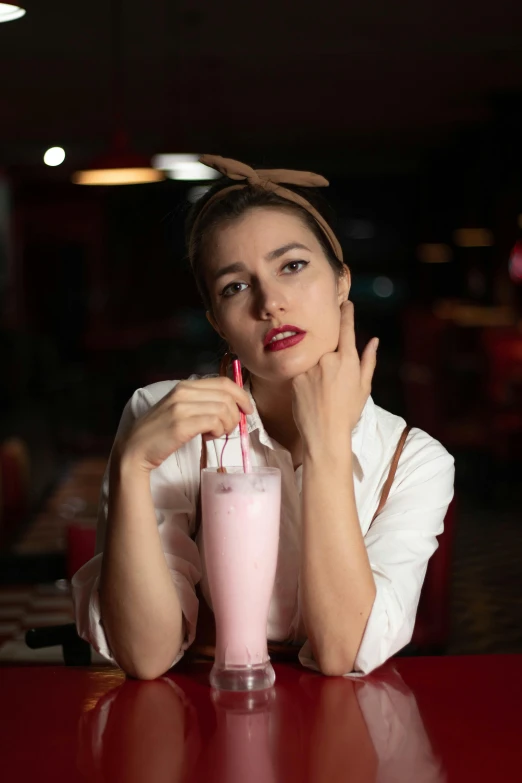 the woman is drinking milkshake in a cafe