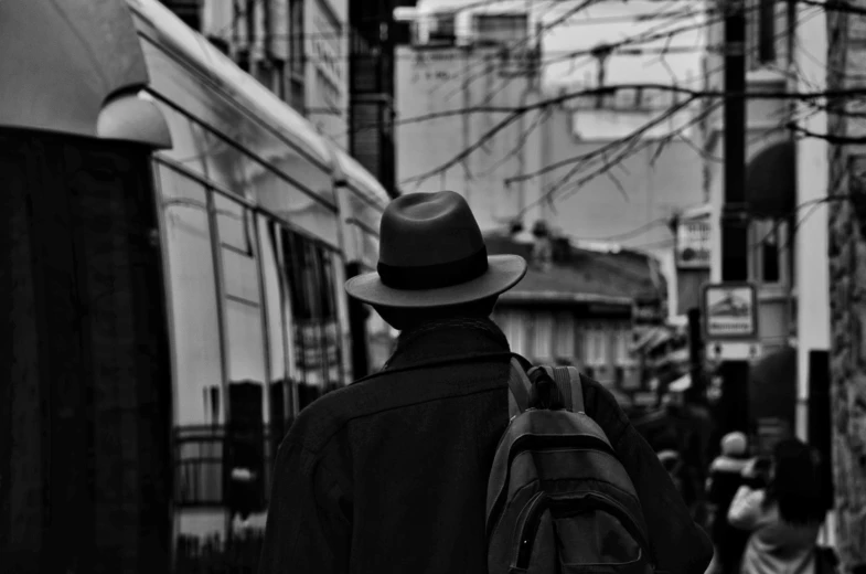 a man walking down a street wearing a backpack