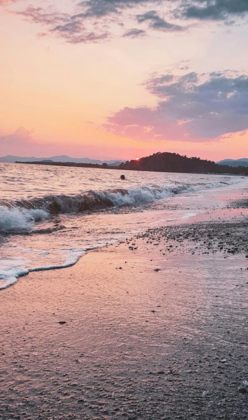 a person riding skis on a beach at sunset