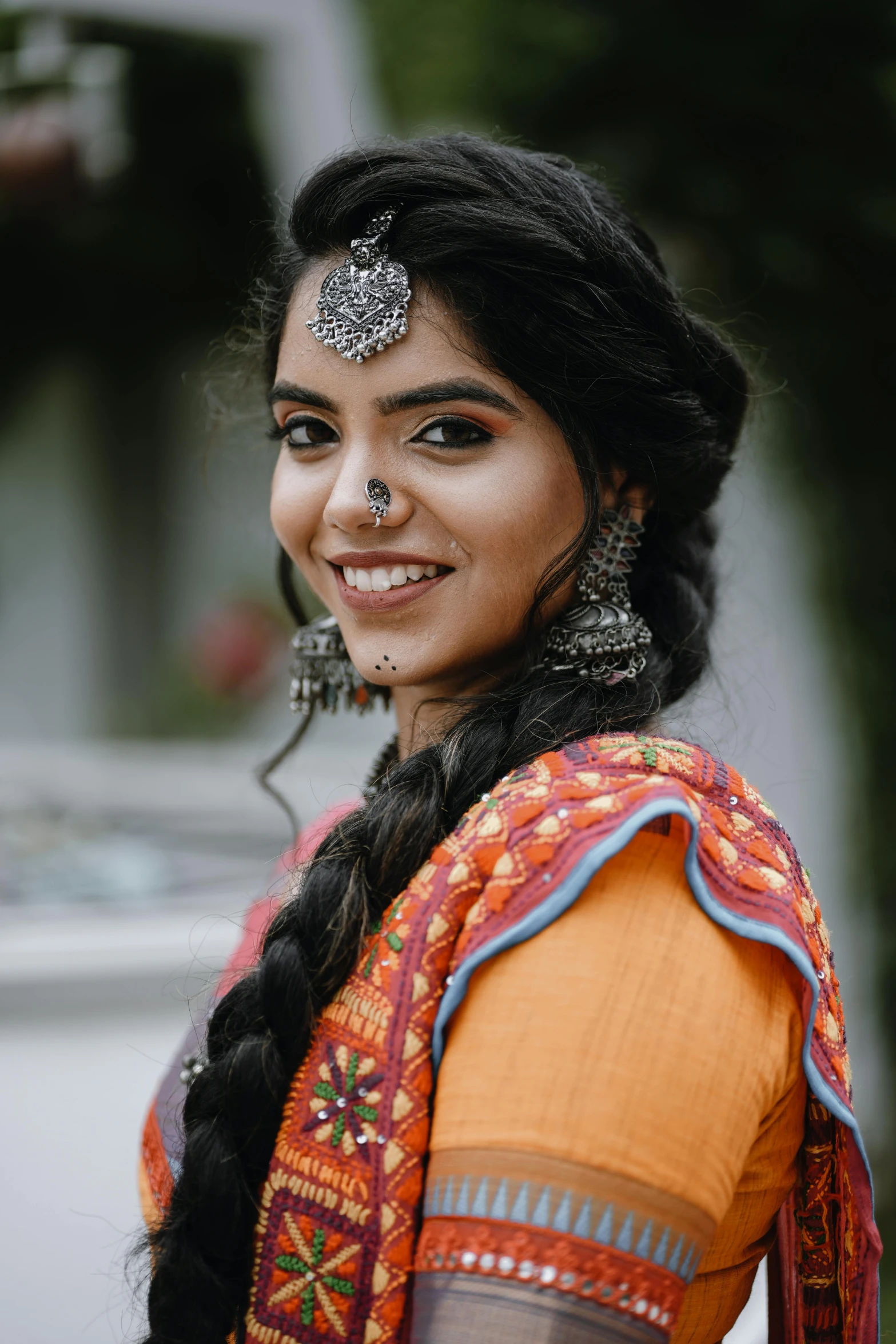 a woman with lots of hair smiling in a headpiece