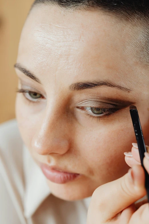 a woman holding a pen up to her nose