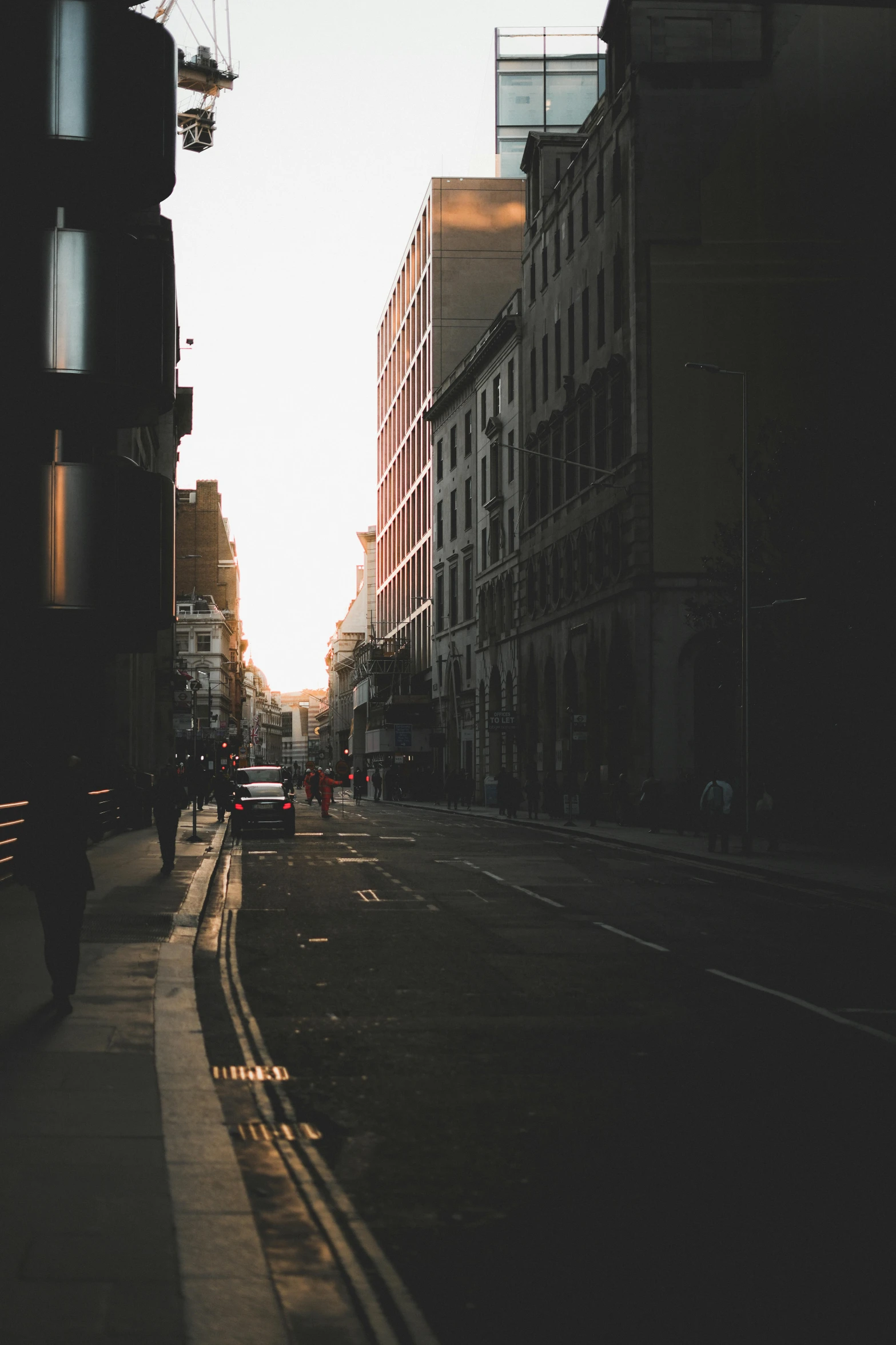 the sun is setting on an empty city street