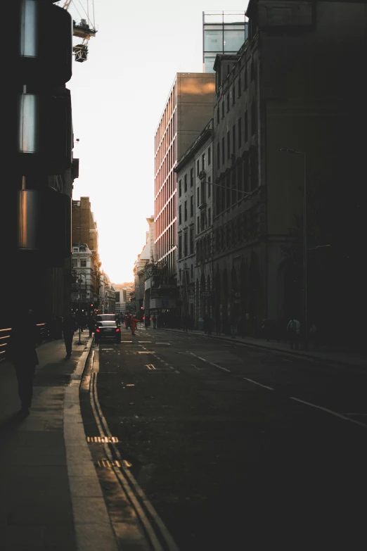 the sun is setting on an empty city street