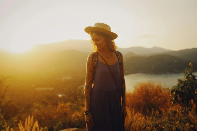 there is a woman standing on a hill overlooking a lake