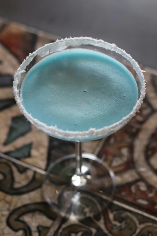 an upclose martini sits on top of a mosaic table