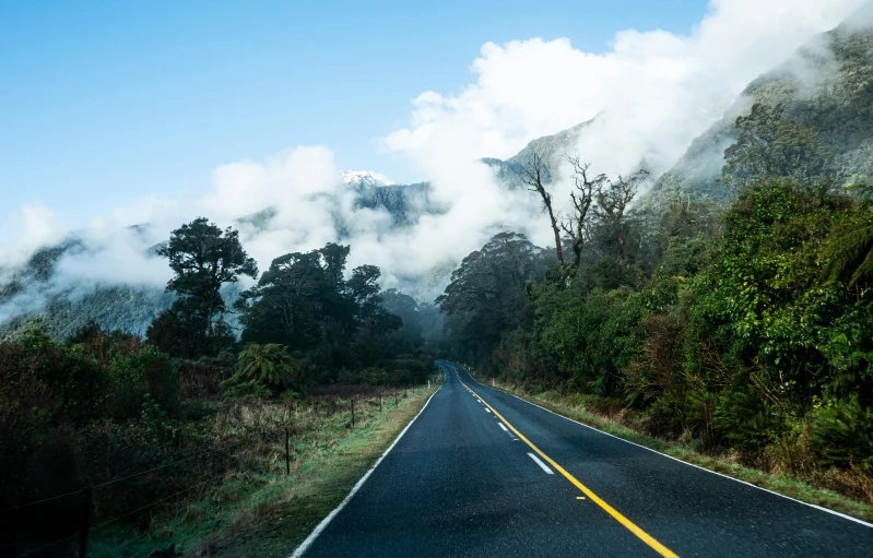 a car drives down the road in front of fog