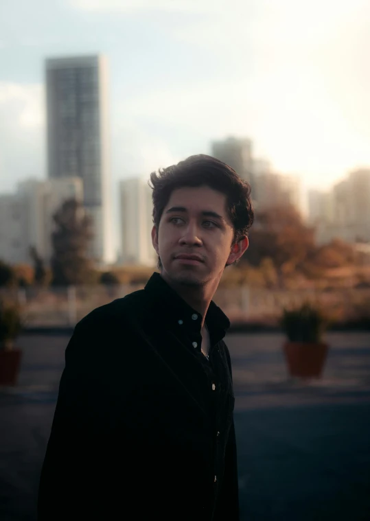 a man standing outside with buildings in the background