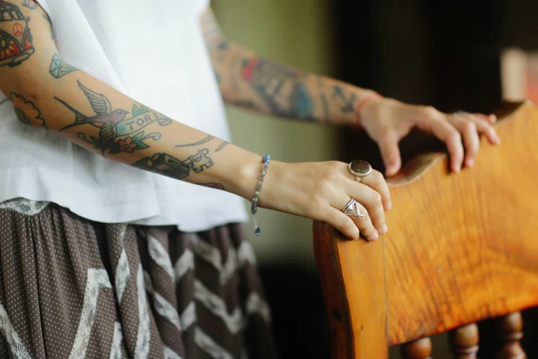 someone is holding the handle of a chair that is wooden