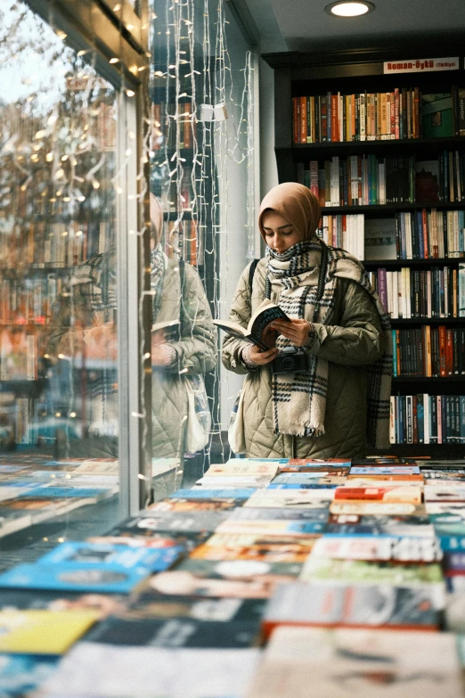 a woman is looking through the window at books