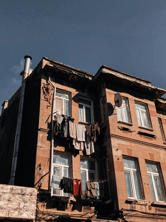 a tall building with clothes on the line on the windows