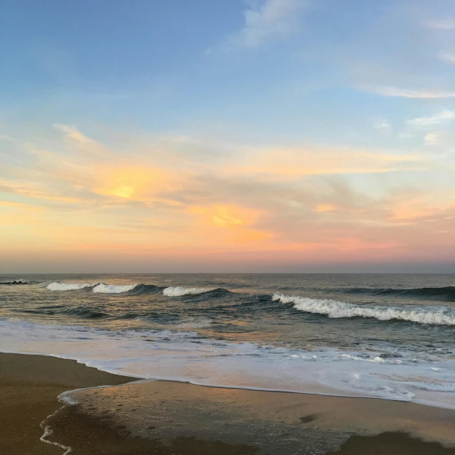 the waves are crashing on the sandy shore