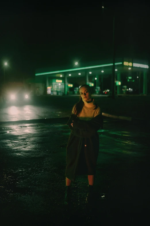 a woman standing on the sidewalk at night