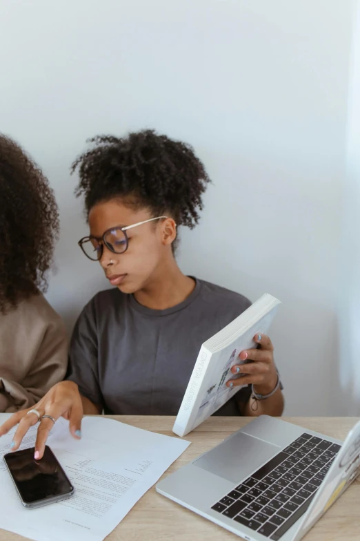 two young women looking at a cell phone