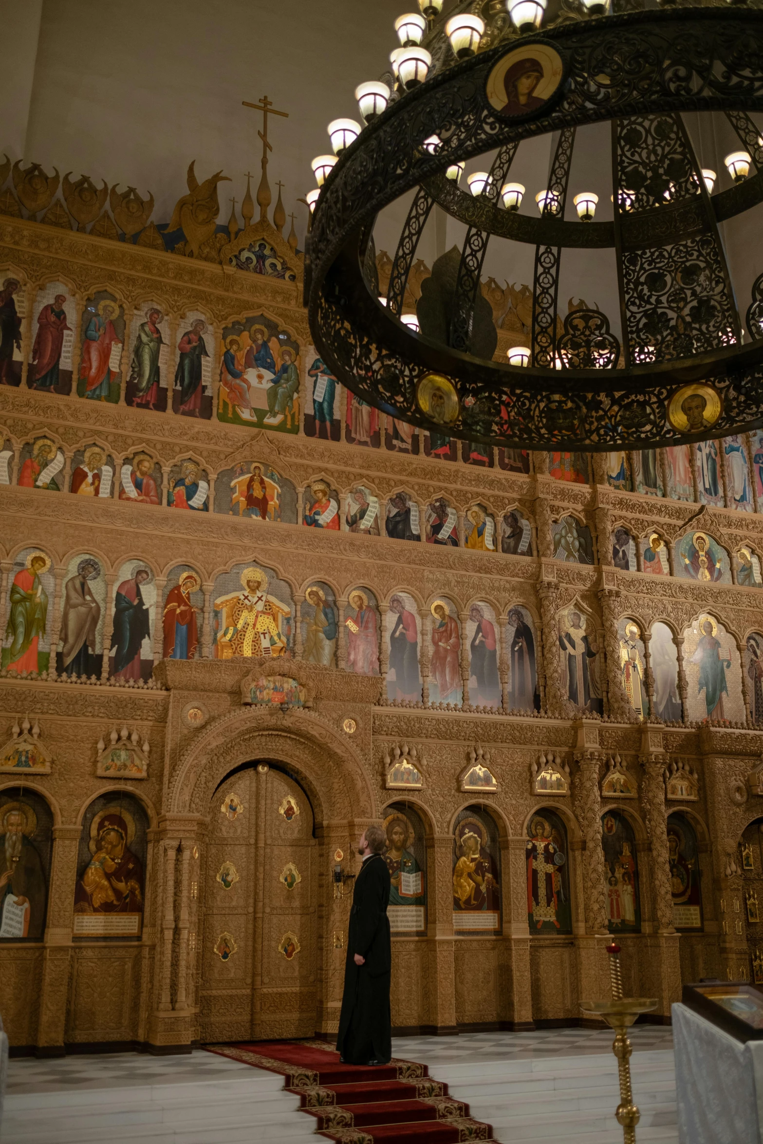 a nun stands before the ornate altar of a cathedral