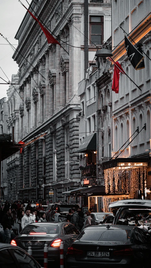 cars driving past large buildings on the city street