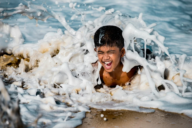 a boy is in the water and is playing in the surf