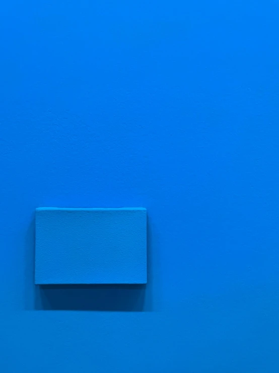 a square blue block on the wall with a metal handle